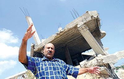 الفلسطيني عباس حلاوة يقف امام احد المنازل التي هدمت في بيت لاهيا شمال قطاع غزة، ويؤكد ان الجيش الاسرائيلي استخدمه كدرع بشري