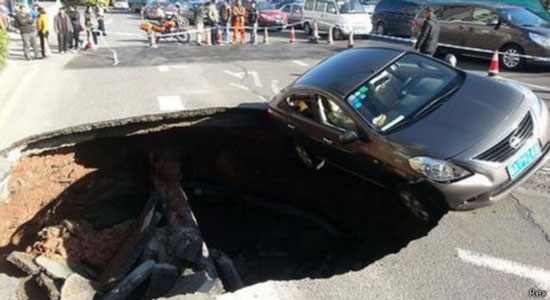 سيارة كانت على وشك السقوط في حفرة أحدثها انهيار أرضي مفاجئ في الصين