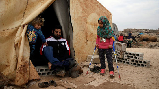 مايا مرعي الى جانب والدها المعوق امام خيمة عائلتها في احد المخيمات في شمال غرب سوريا 