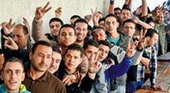 شباب يشيرون بعلامة النصر أمام إحدى لجان الاستفتاء ببورسعيد