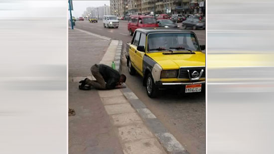سائق تاكسي يؤدي الصلاة في الشارع