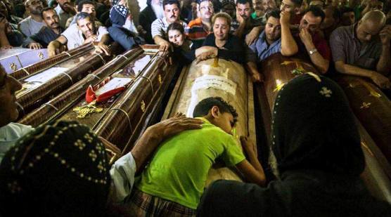 طفل يحتضن جثامين والديه بالجنازة