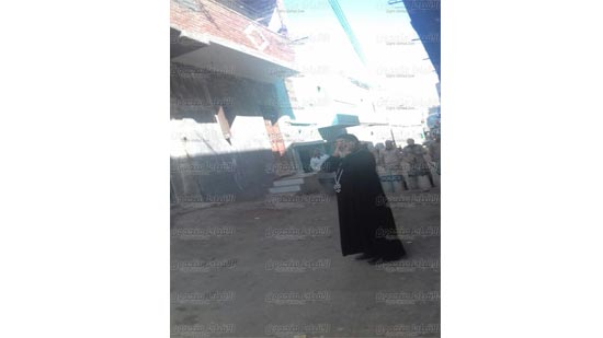 بالصور ..كاهن قرية الفرن بالمنيا أمام الحواجز الأمنية بعد منعه الدخول للصلاة 