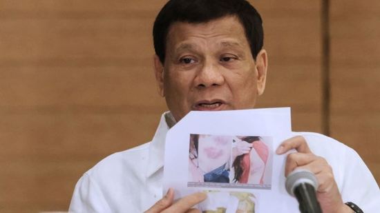 الرئيس الفلبيني ملوّحاً بصورة الخادمة المقتولة