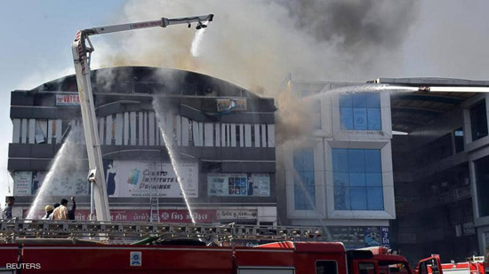 محاولة إطفاء الحريق الذي شب في مبنى بمدينة سورات الهندية