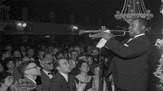 عازف الجاز الأمريكي لويس أرمسترونج اثناء احياء حفل وسط جمهوره 