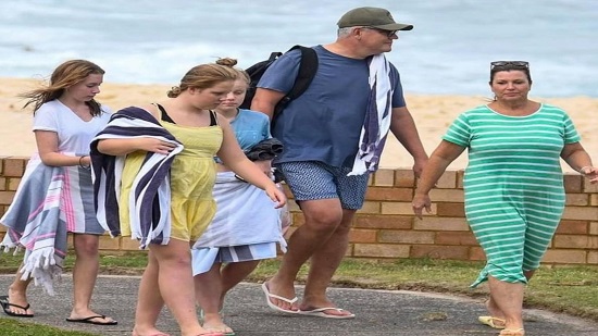 بالصور رئيس الوزراء الأسترالى يمارس السباحة مع أسرته فى أحد شواطئ سيدنى