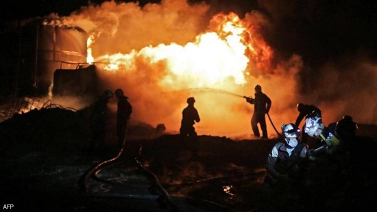 رجال الإطفاء يحاولون إخماد الحريق الناجم عن القصف