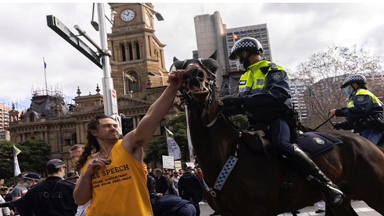 بالصور متظاهر يوجه لكمة لحصان الشرطة خلال تظاهرات مناهضة للإغلاق بأستراليا