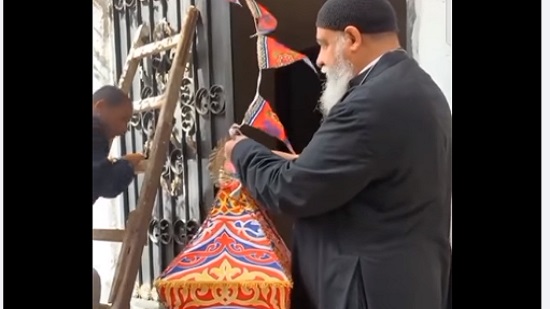 فيديو .. رجل دين مسيحي يعلق فانوس وزينة رمضان بمقر خدمات مطرانية الاقباط بالغردقة 